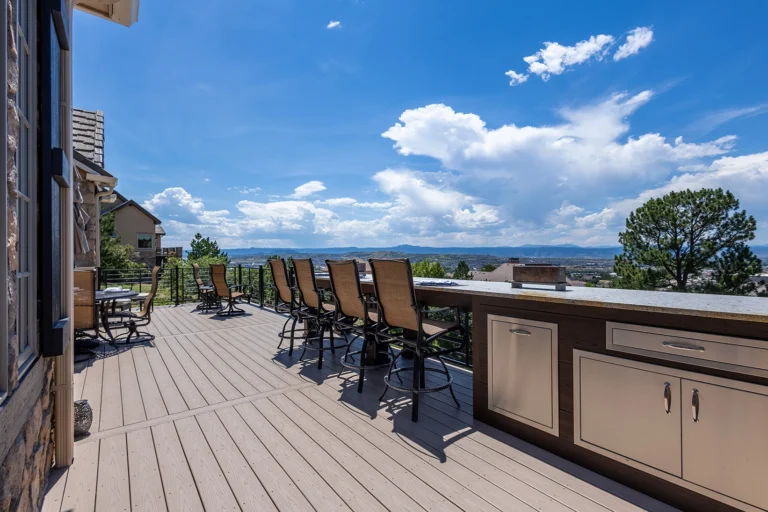 Composite deck with a built-in outdoor kitchen, bar seating, and mountain views