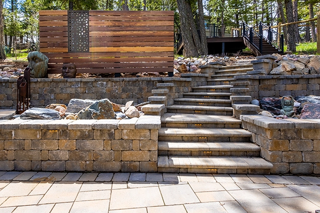 Terraced stone retaining walls with a wide staircase and planted beds